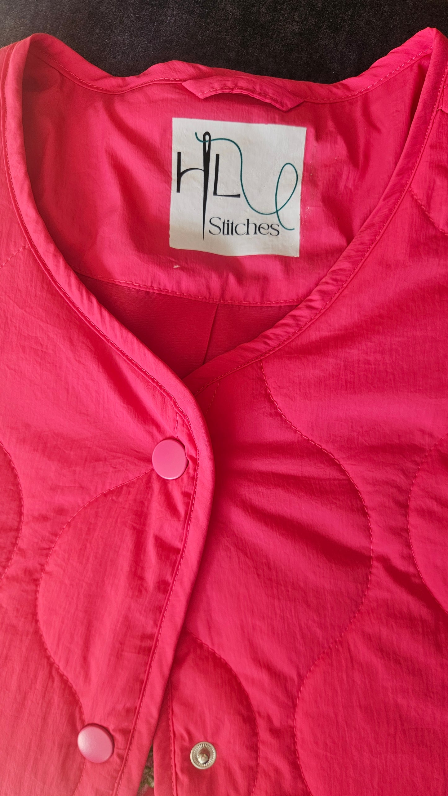 Vibrant pink quilted shower proof jacket with floral embroidery