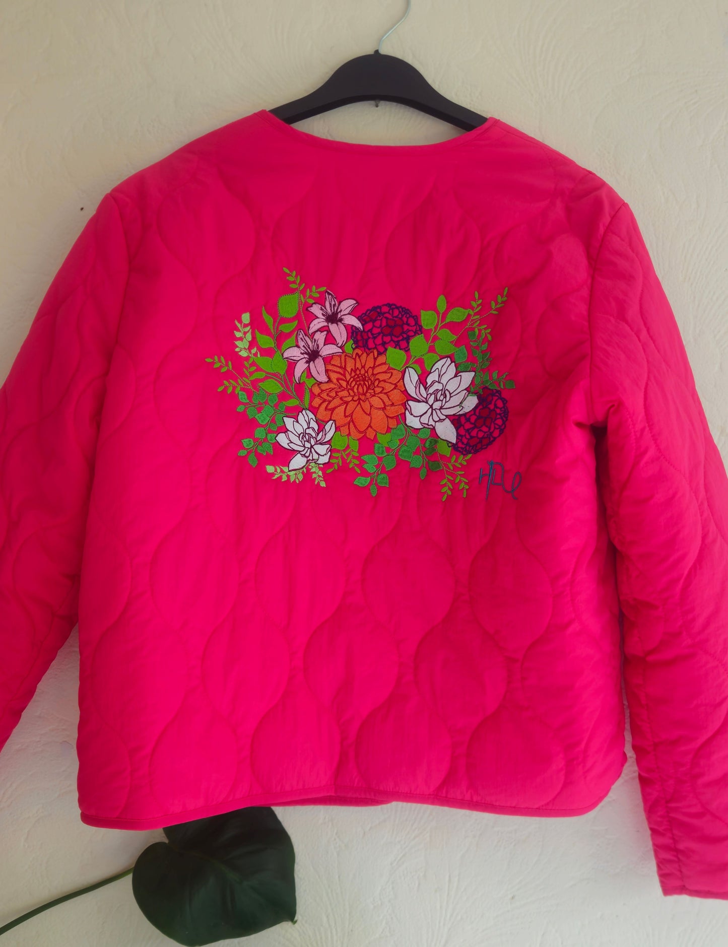 Vibrant pink quilted shower proof jacket with floral embroidery