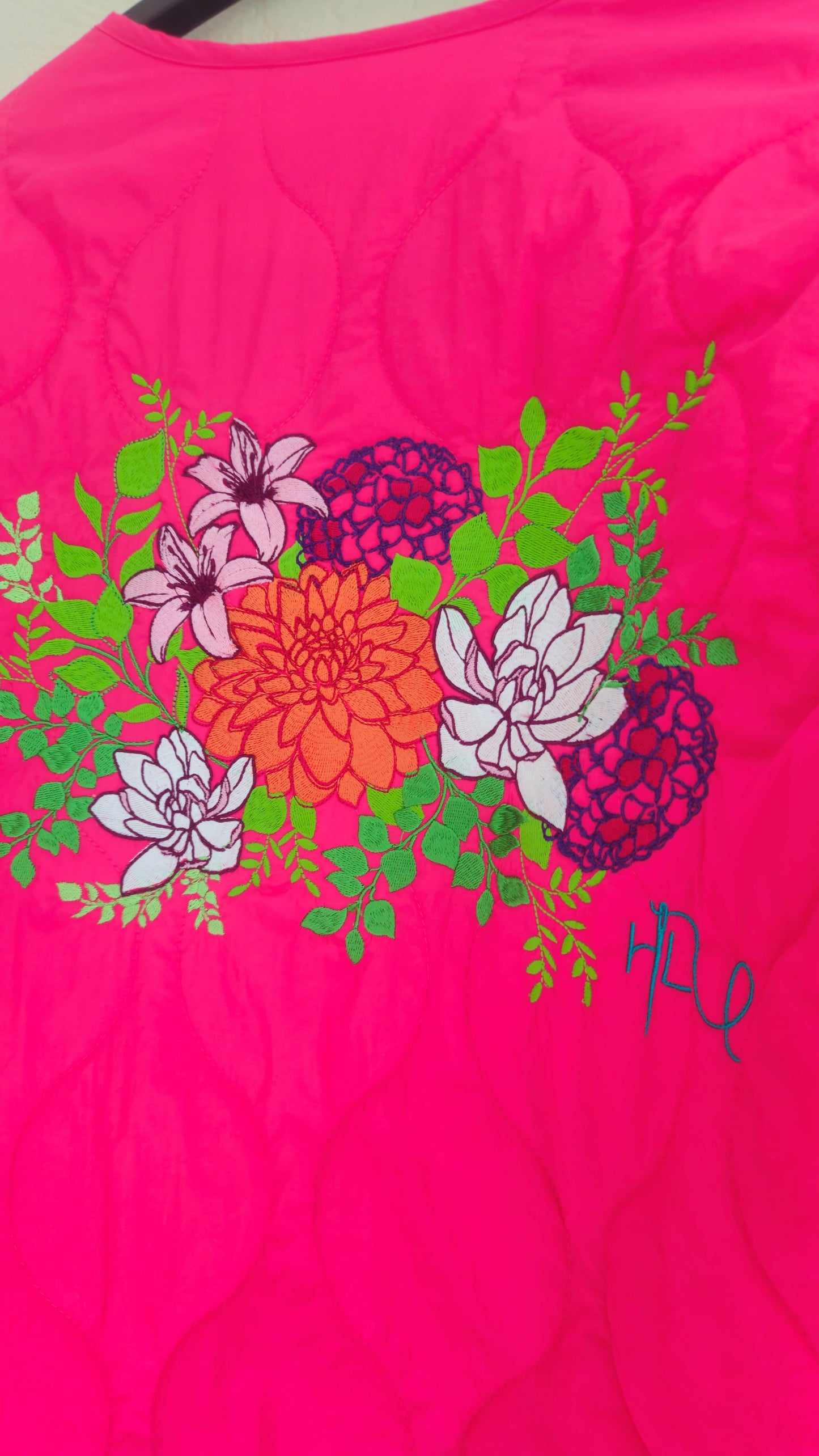 Vibrant pink quilted shower proof jacket with floral embroidery